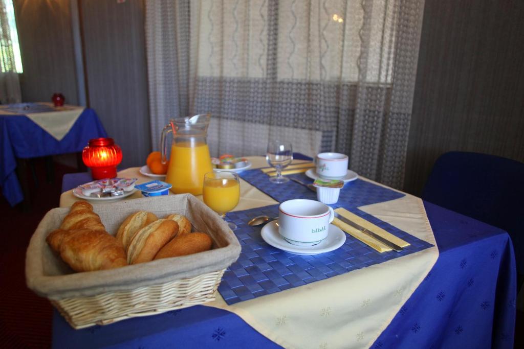 - une table avec un panier de croissants et de jus d'orange dans l'établissement Le Relais de Fabrègues, à Fabrègues