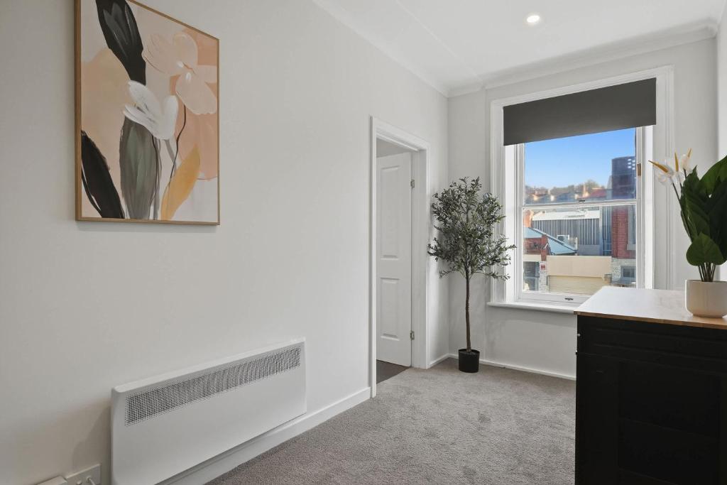 a white room with a fireplace and a window at Hobart CBD Loft - Walking to CBD in Hobart