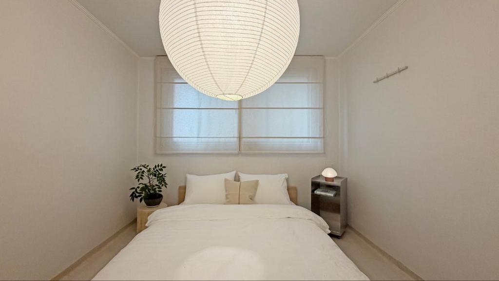 a bedroom with a large bed and a large chandelier at SOYO-SOOP Stay in Seoul