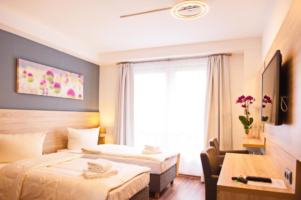 um quarto de hotel com duas camas e uma janela em BlnCty Hotel em Berlim
