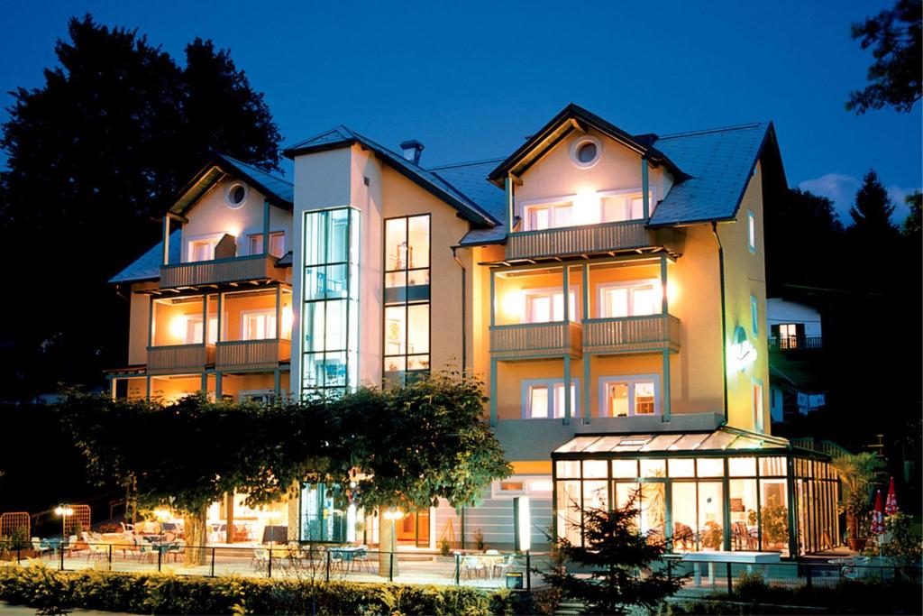 a large building with its lights on at night at Newly renovated Boutique Hotel Giulia Slow Residence in Velden am Wörthersee