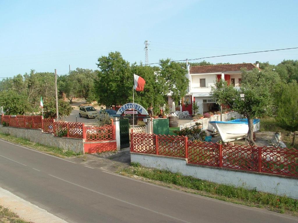 une clôture rouge sur le côté d'une rue dans l'établissement Vivi Natura Agriturismo, à Gallipoli