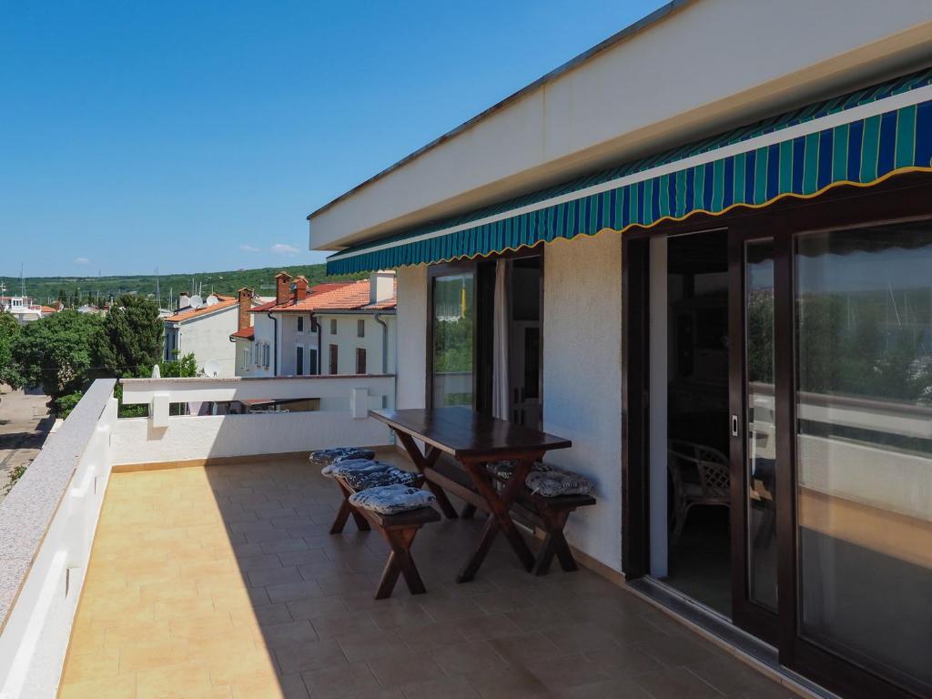a balcony with a wooden table and chairs at Apartman Seven Waves in Punat