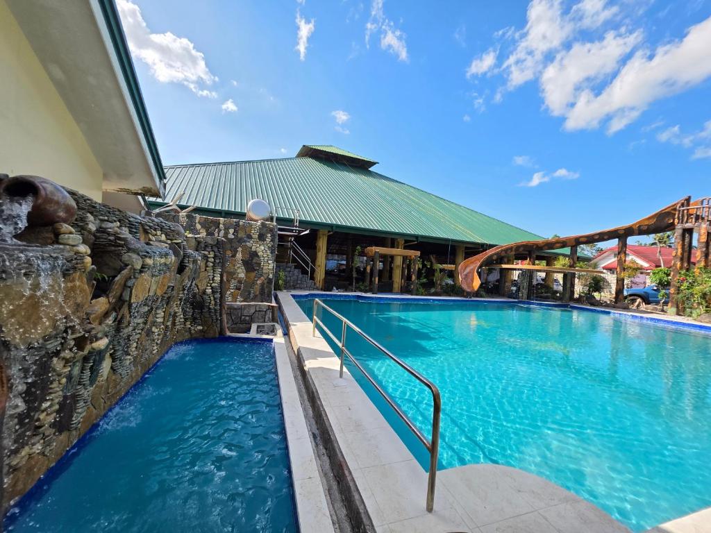 a pool at a resort with a rock wall at Gilkrissa Garden in San Nicolas