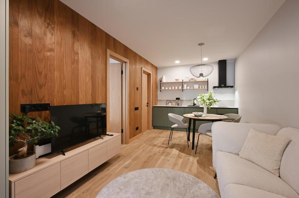 a living room with a tv and a couch and a table at Albatross Home in Ķesterciems