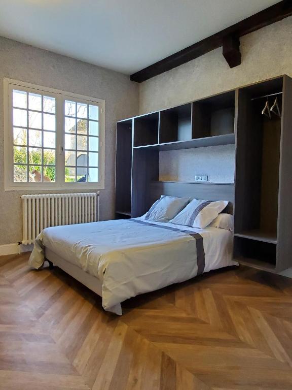 a bedroom with a large bed with a large headboard at Logement authentique et facile d'accès in Sermoise
