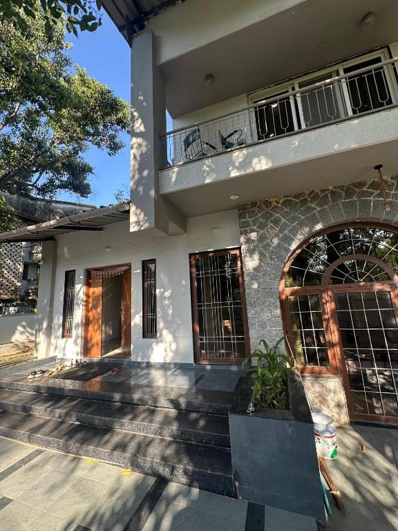 a house with a balcony on top of it at Atishay Villa I 4BHK I Pure veg I Pvt Pool & lawn in Lonavala