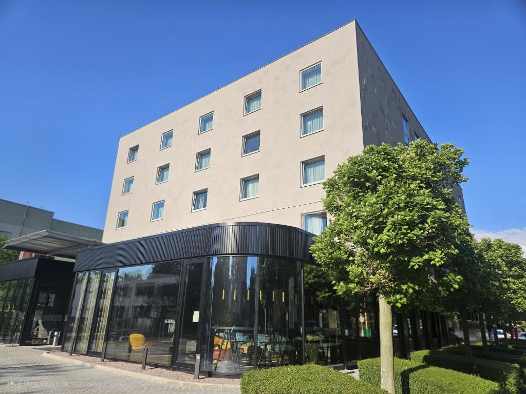 a building with a tree in front of it at Hotel Euro in Pardubice