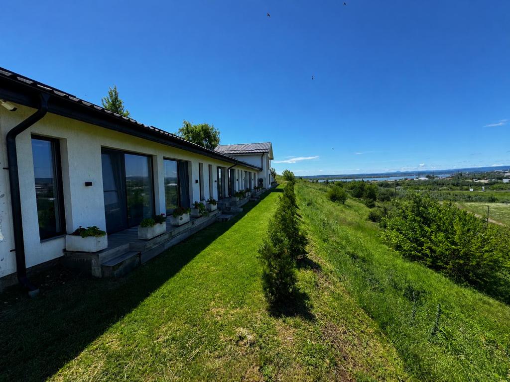 a house with a green lawn next to a building at Hill House in Drobeta-Turnu Severin