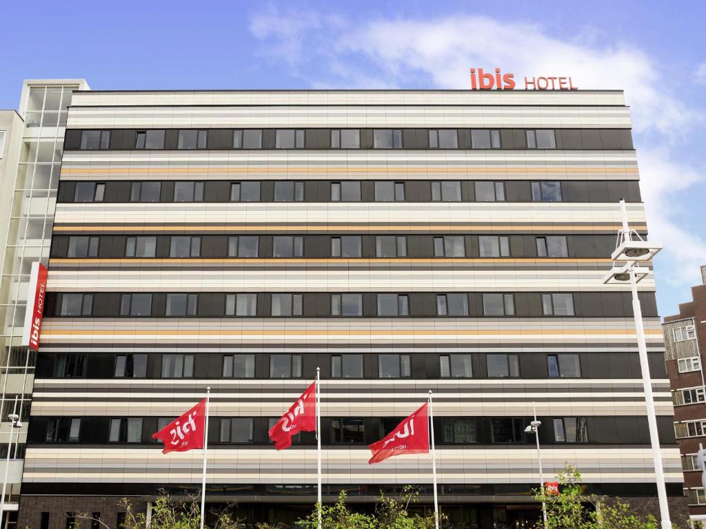 a building with red canadian flags in front of it at ibis Leiden Centre in Leiden