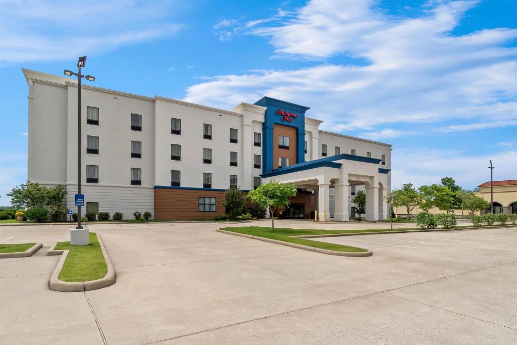 a large white building with a parking lot at Hampton Inn Marion in Marion