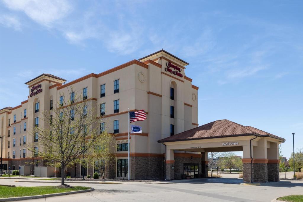 an office building with an american flag in front of it at Hampton Inn & Suites West Des Moines Mill Civic in West Des Moines