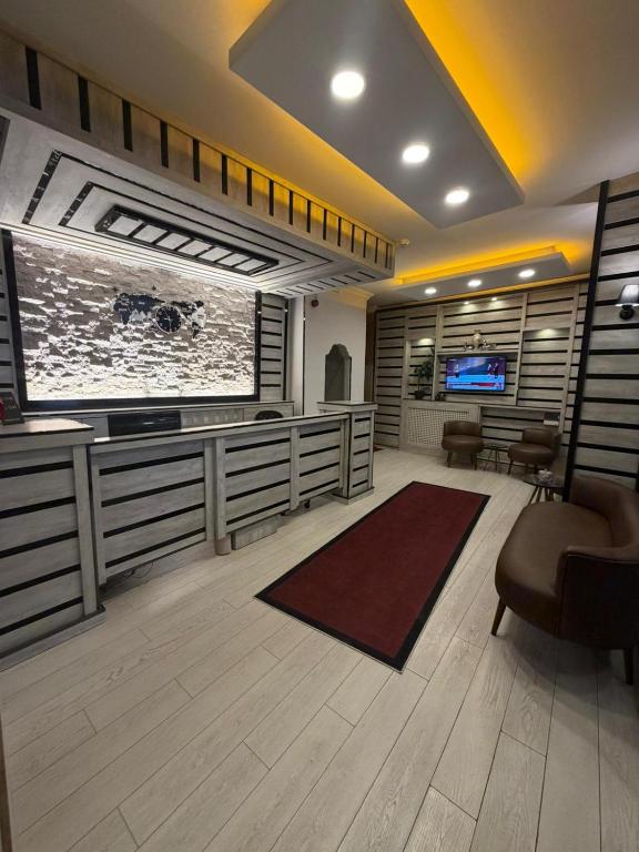 ein Wohnzimmer mit einem großen Flachbildfernseher und einem Sessel in der Unterkunft KONAK HOTEL 2 in Kars
