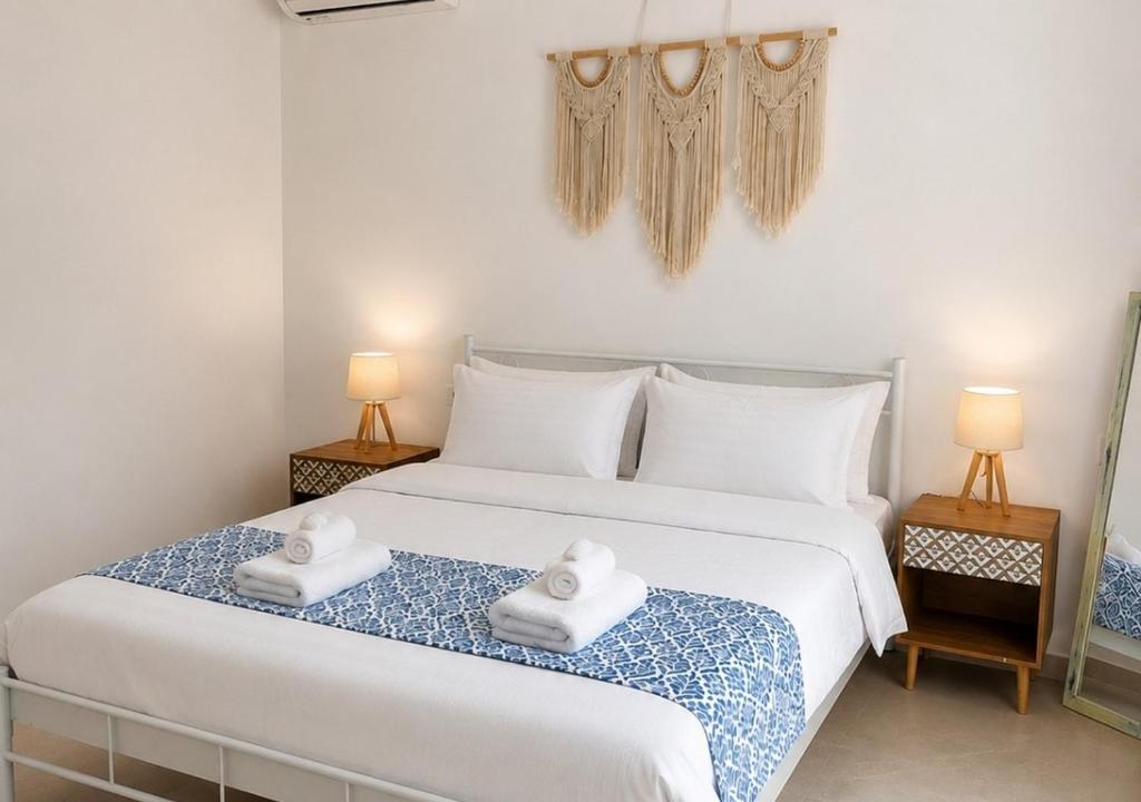 a bedroom with a large white bed with two towels at Serenity in Petra