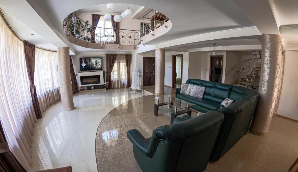 a living room with two green couches and a table at Elegant Private Villa with 3 Bedrooms, Office, and shared courtyard, Perfect for 8 Guests in Piteşti