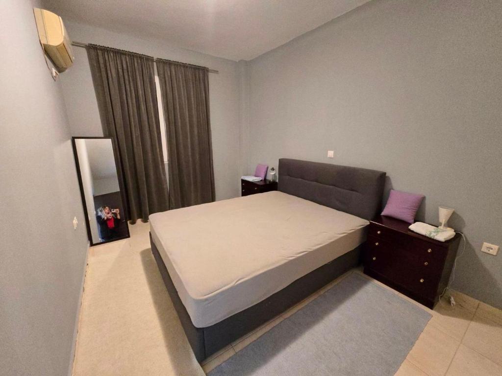 a small bedroom with a bed and a window at Patras Ressort in Patra