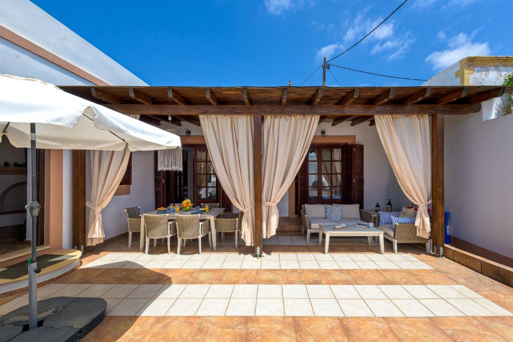 a patio with a table and chairs and an umbrella at Casa Aestas in Lachania