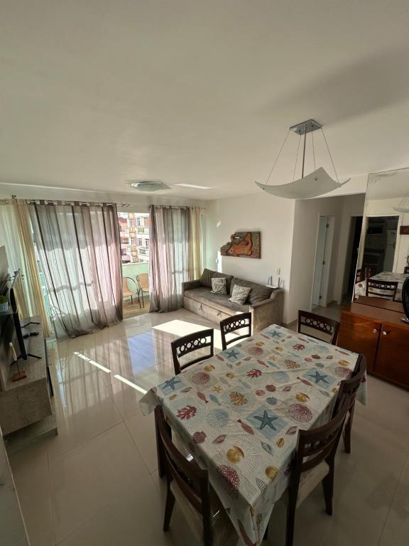 a living room with a table and a couch at Apartamento 2 quartos 100m Prainha in Arraial do Cabo