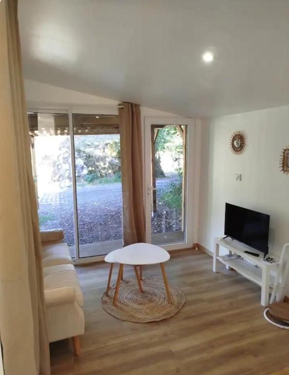 a living room with a table and a tv at Le nid douillet in Aydat