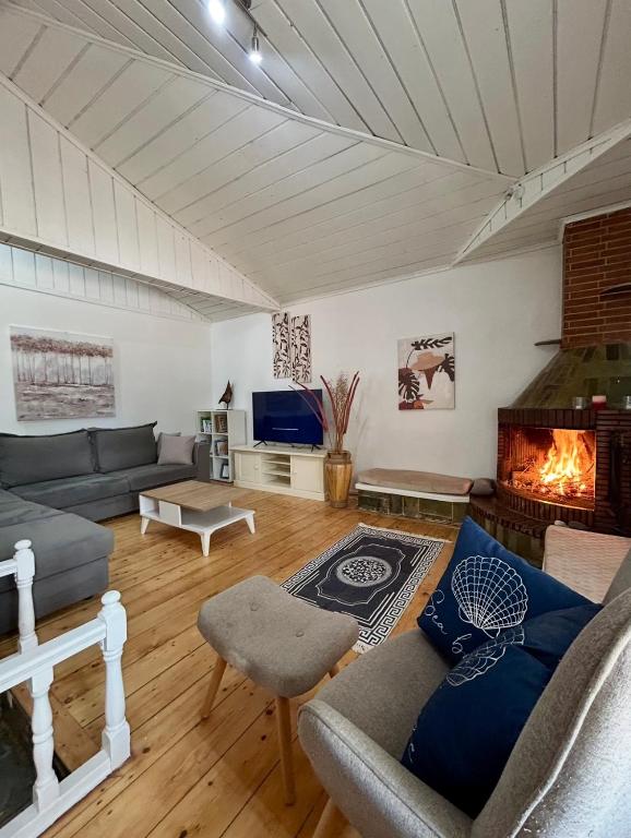 a living room with a couch and a fireplace at Stone & Sea Retreat in Órmos Marathokámpou