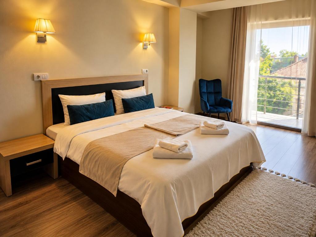 a bedroom with a large bed with two towels on it at Hotel Oxford By TimHotels in Timişoara