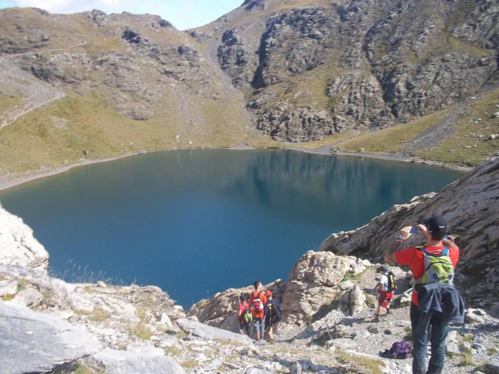 Ein Mann steht auf einem Berg und schaut auf einen See. in der Unterkunft Casa Villamana in Oto