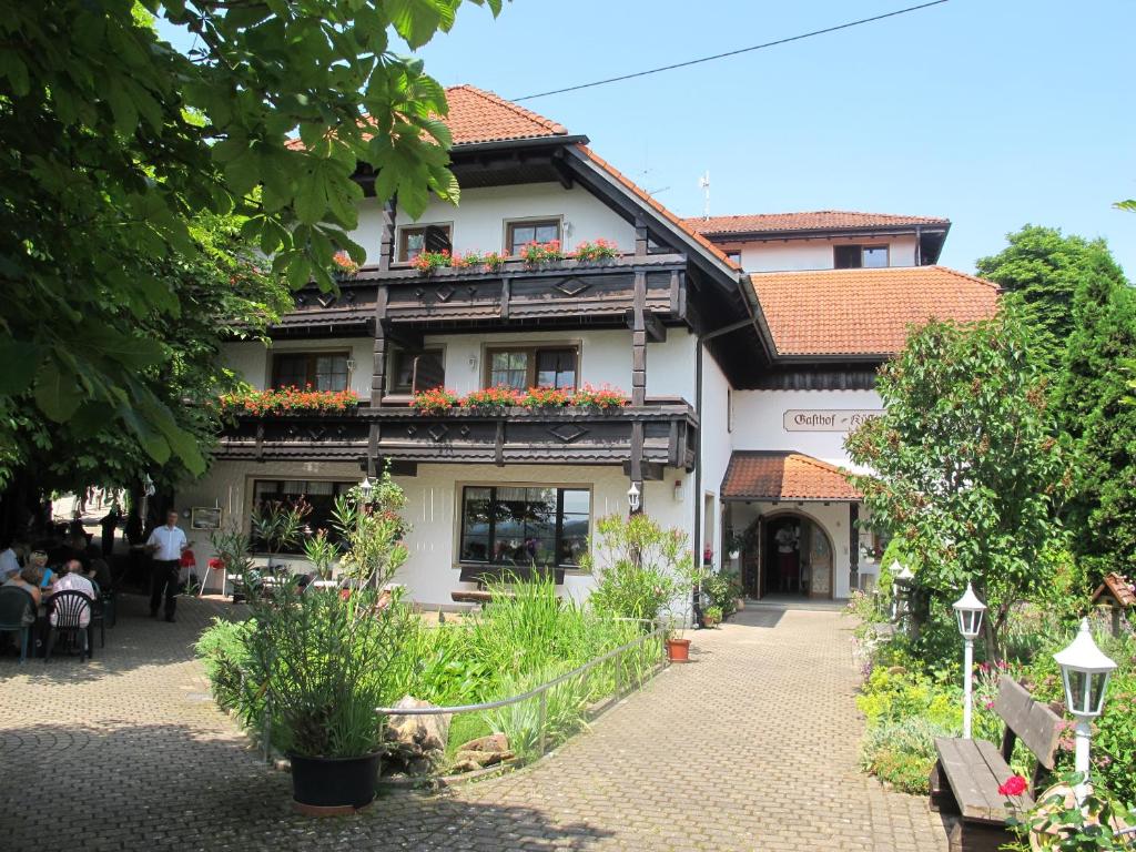 ein Gebäude mit einem Balkon mit Blumen darauf in der Unterkunft Gasthof Küssaburg in Küssaberg
