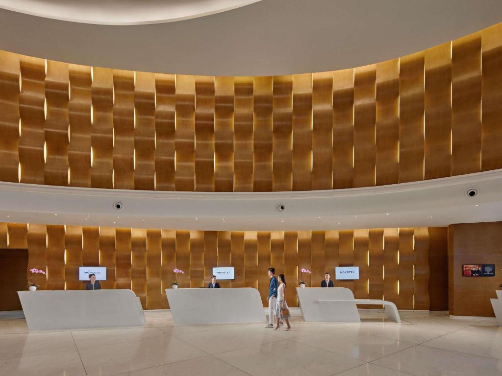 A spacious reception lobby with curved gold-toned wall panels and multiple desks.