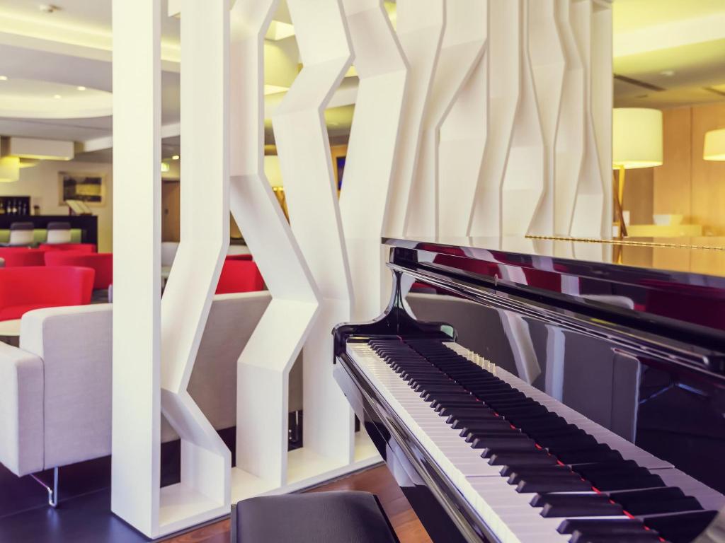 a piano in the lobby of a hotel at Hotel Mercure Braga Centro in Braga