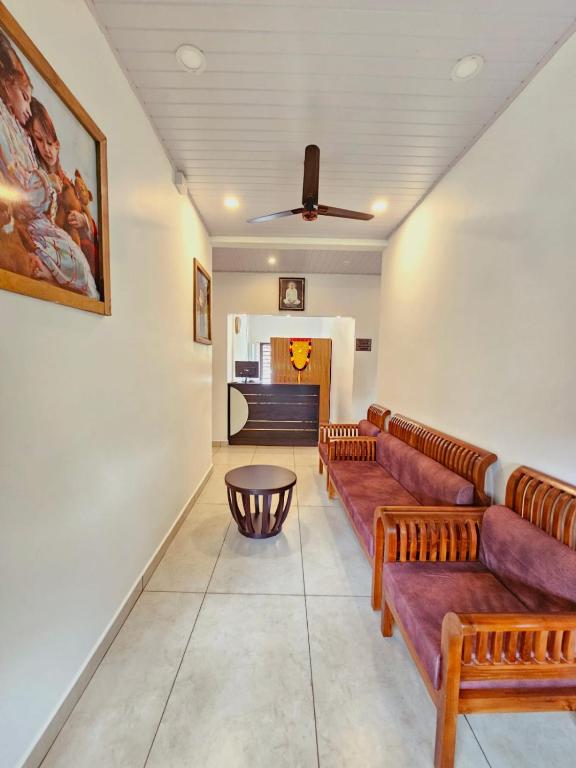 a living room with couches and a table at Thekkady Nest Residency in Thekkady