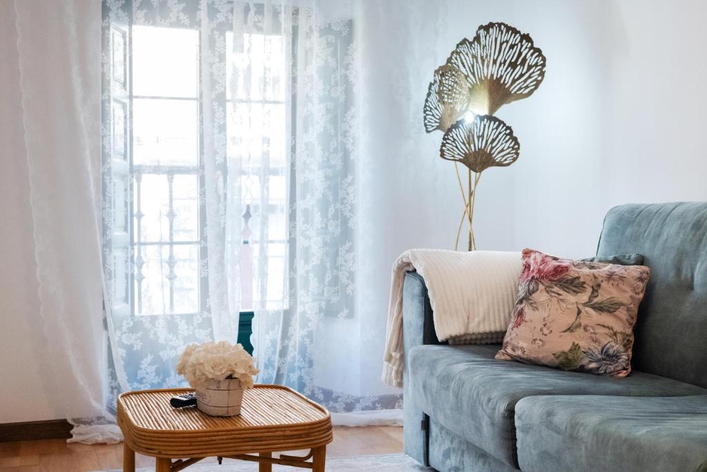 a living room with a blue couch and a table at Apartamentos El Escudo Centro in Ribadesella