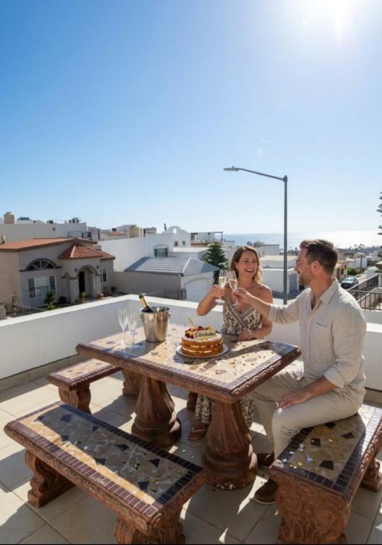 a man and woman sitting at a picnic table on a roof at Oceanview house in El Suazal