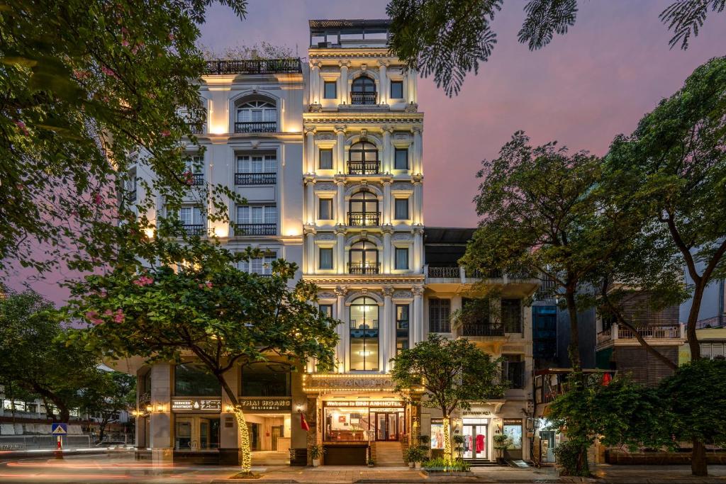 a tall white building with lights on at Binh Anh Hotel in Hanoi