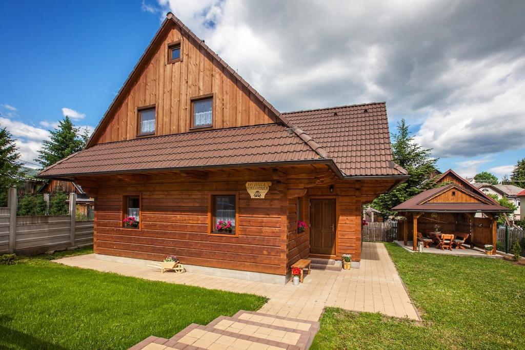 a large wooden house with a gambrel roof at Drevenica Horehronka in Závadka nad Hronom