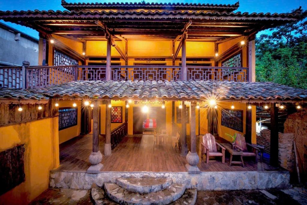 a porch of a house with lights on it at Khói Bản Homestay in Dồng Văn