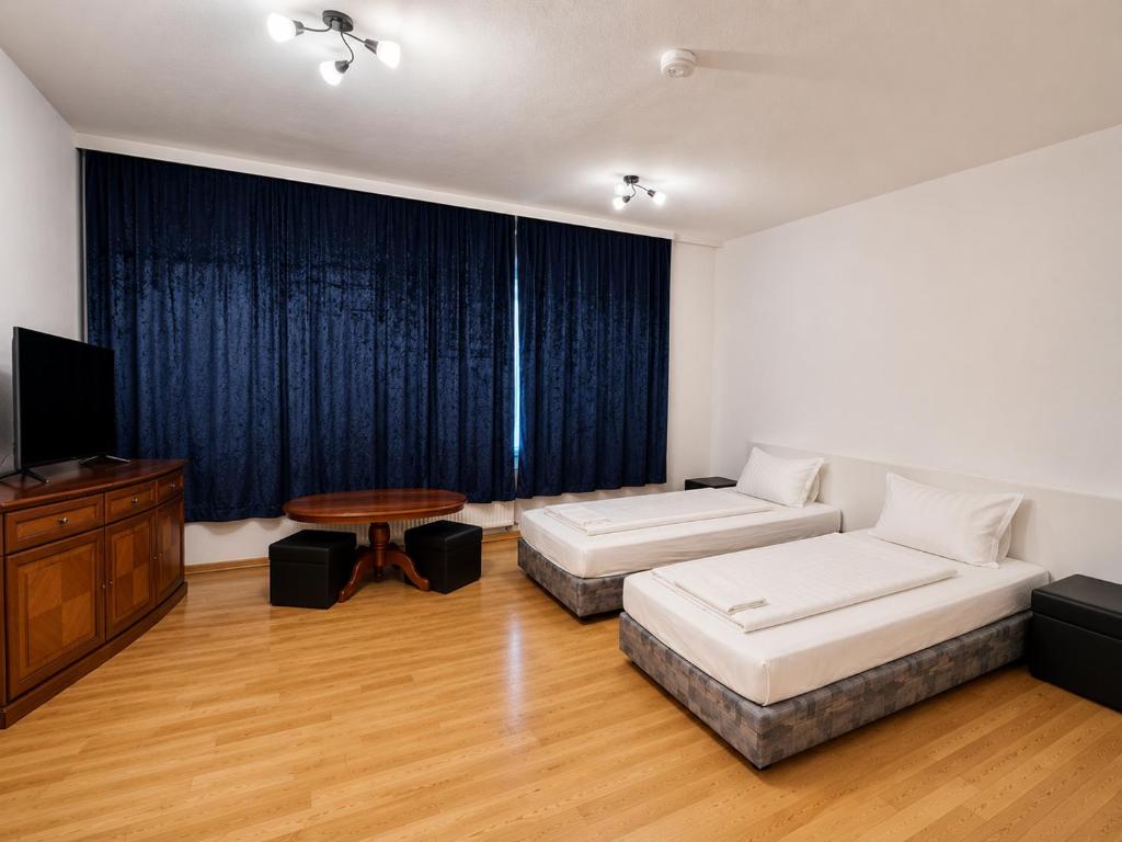 a room with two beds and a table and a television at Ferien Wohnung in Chemnitz