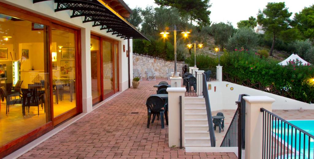 a restaurant with tables and chairs on a brick sidewalk at Residence Chiesiola in Vieste