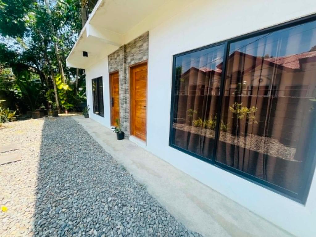 a facade of a house with large windows at Sapayag Backpacker's Inn in Dipolog