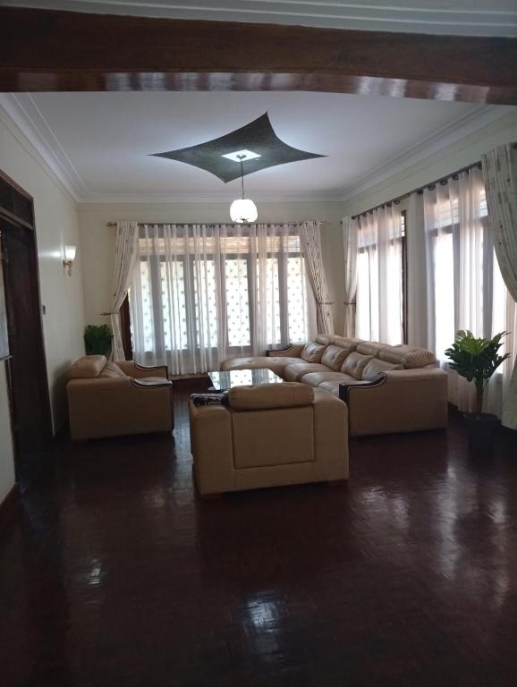 a large living room with couches and a ceiling at Spring homes2 in Jinja