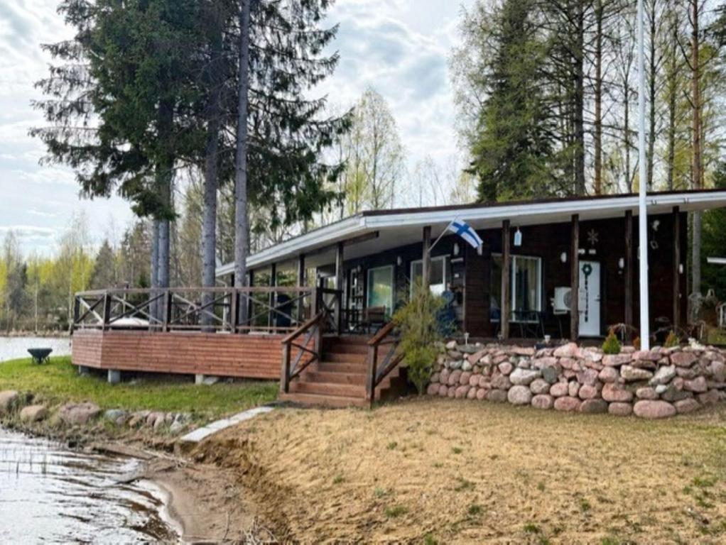 a house on the shore of a body of water at Tilhi 1 Cottage in Piojärvi