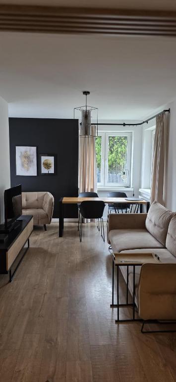 a living room with couches and a dining table at Apartament z ogrodem Cyprysowy zakątek in Oświęcim