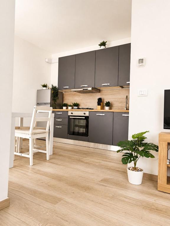 a kitchen with gray cabinets and a table and a plant at A due passi dal mare in Giulianova