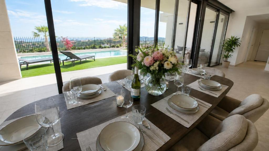 a dining room table with a vase of flowers on it at Villa Kala in Polop