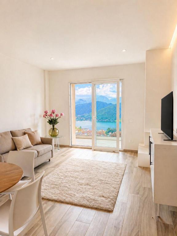 a living room with a couch and a large window at Lake View Apartament 39 - Free Parking & Terrace in Cadegliano Viconago