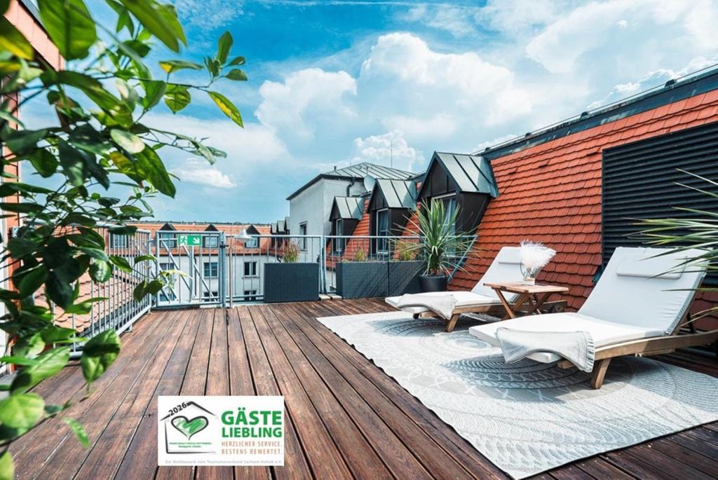 a deck with two chairs and a table on a building at martas Hotel Lutherstadt Wittenberg in Lutherstadt Wittenberg