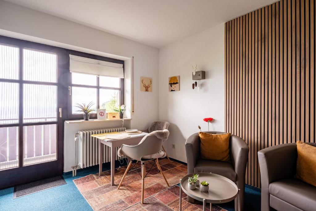 a living room with a couch and a table and chairs at Appartement Bergluft in Sasbachwalden