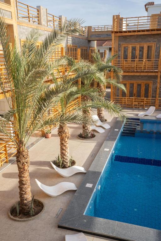 a hotel with palm trees and a swimming pool at Amun Dahab Hotel in Dahab