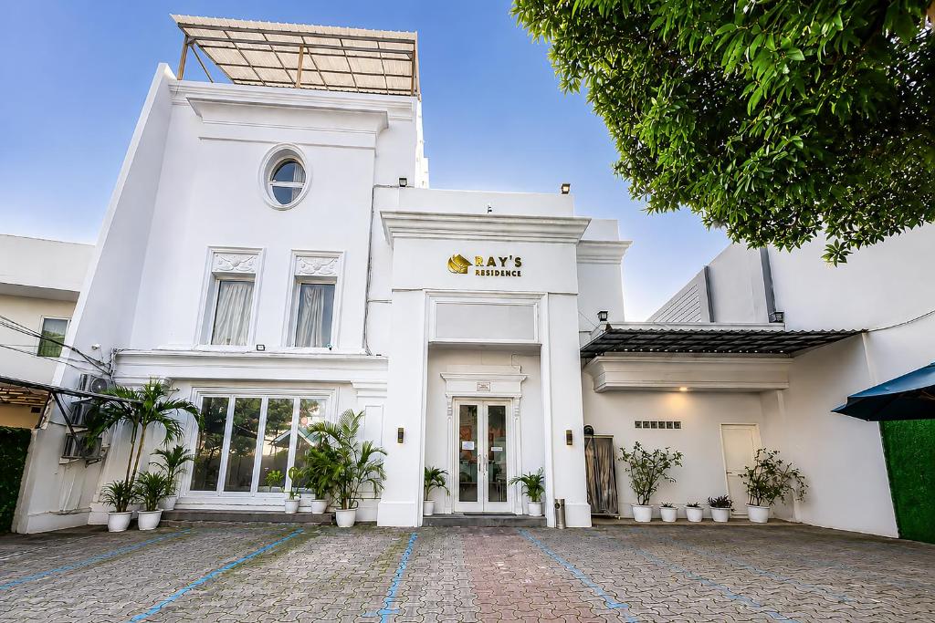 a white building with a sign on it at Rays Residence in Jakarta