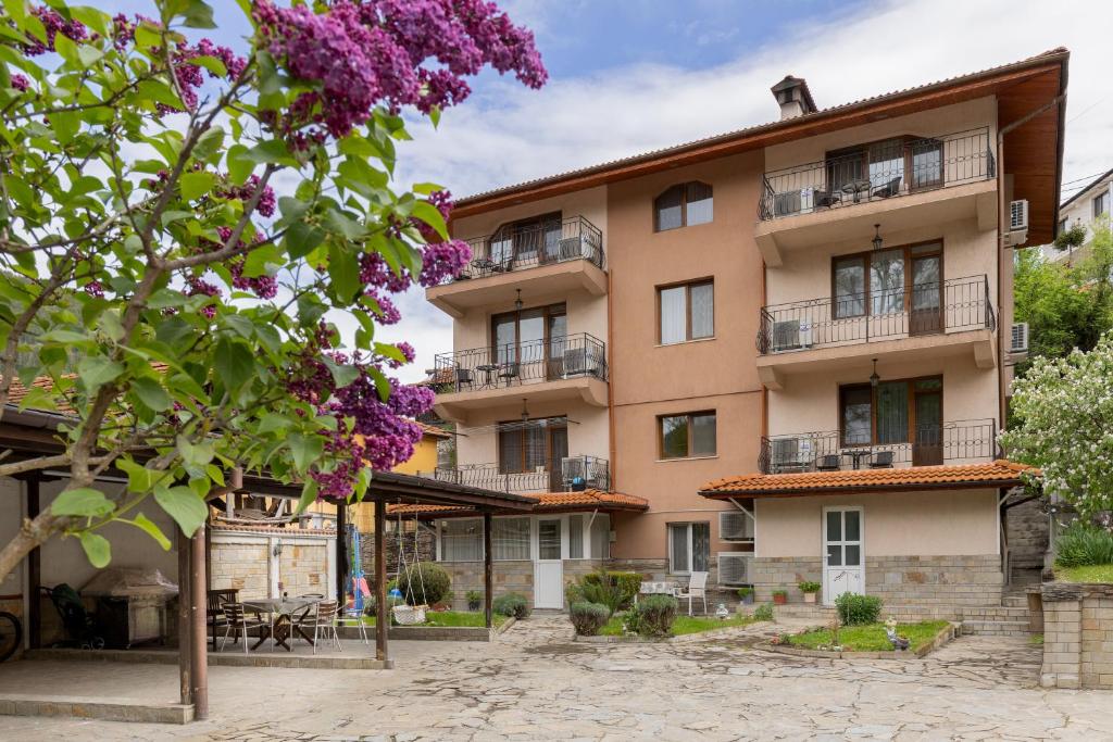 a building with purple flowers in front of it at Къща за гости Бонев in Devin