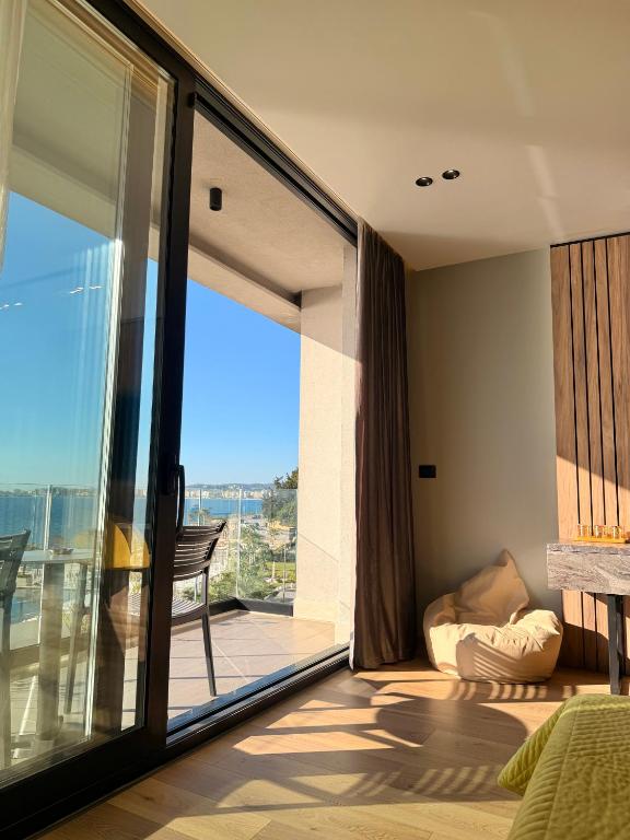 a bedroom with a large glass door with a balcony at Esbjerg Hotel in Vlorë